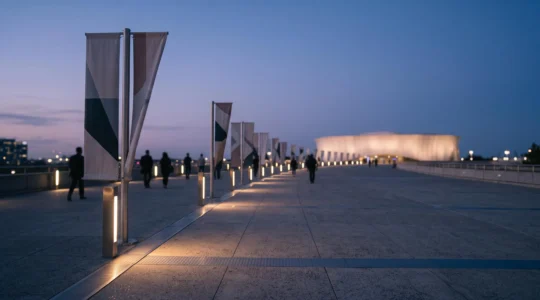 Visiteurs guidés par un jeu de lumières et de structures vers un espace d'exposition lors d'un événement en extérieur au crépuscule